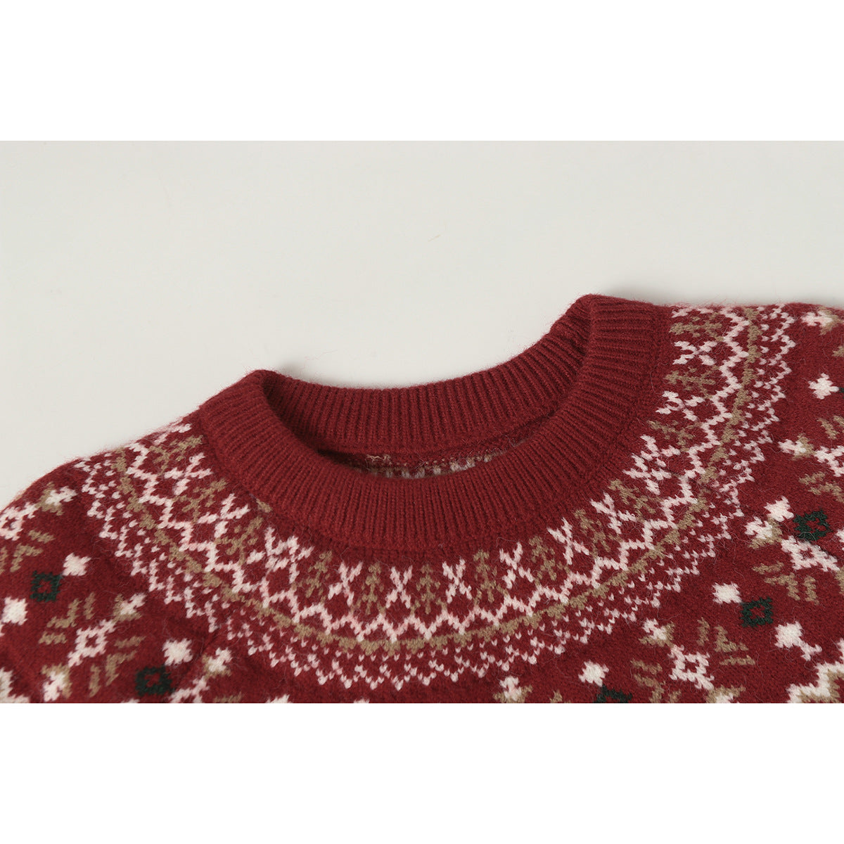 Close-up of a burgundy sweater's ribbed crew neck and cream, taupe, and dark green patterned yoke.