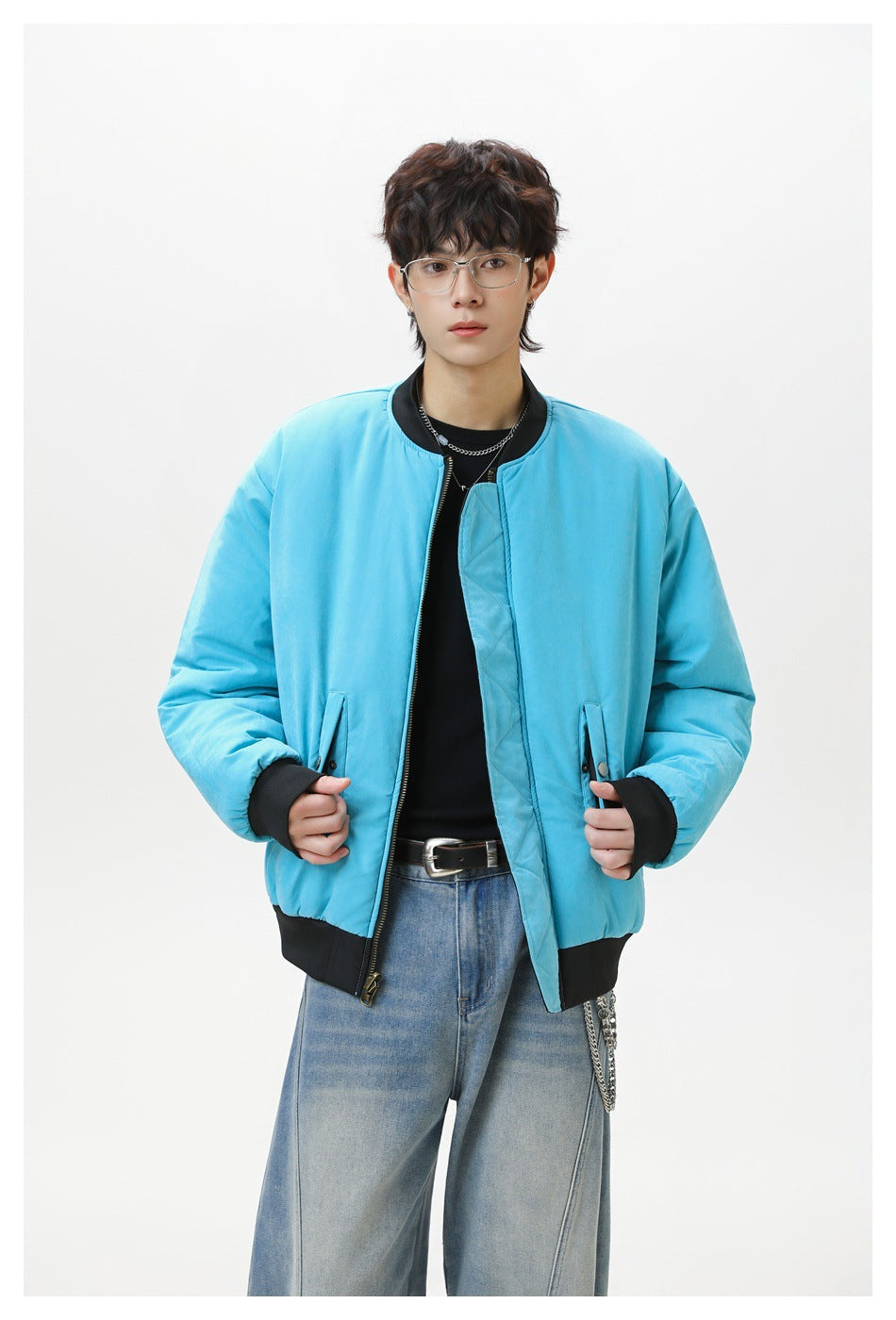 Model wearing a bright turquoise bomber jacket with black ribbed collar, cuffs and hem.