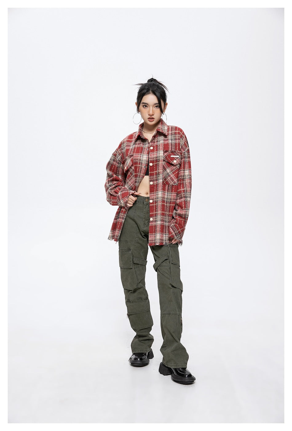 Full-length view of a model wearing a red plaid shirt jacket with dark olive cargo pants.