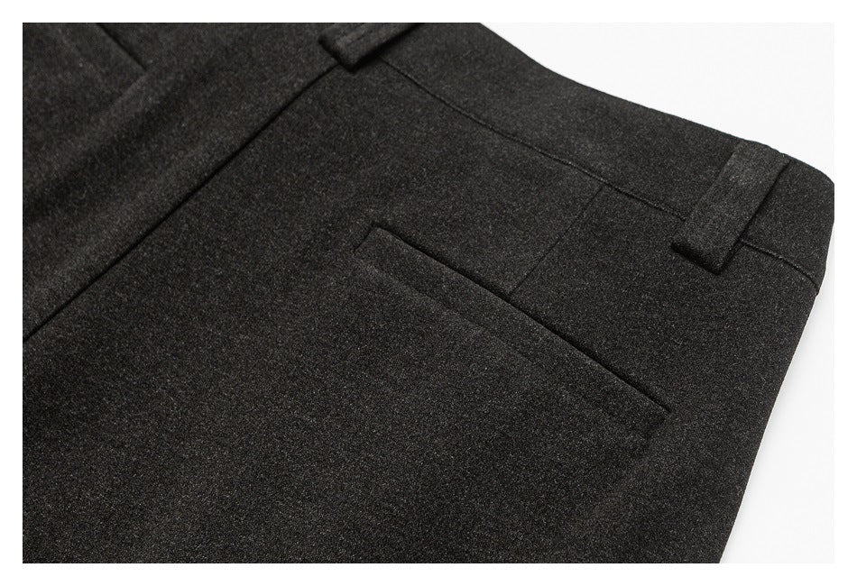 Close-up of a charcoal trouser welt pocket and waistband with a belt loop.