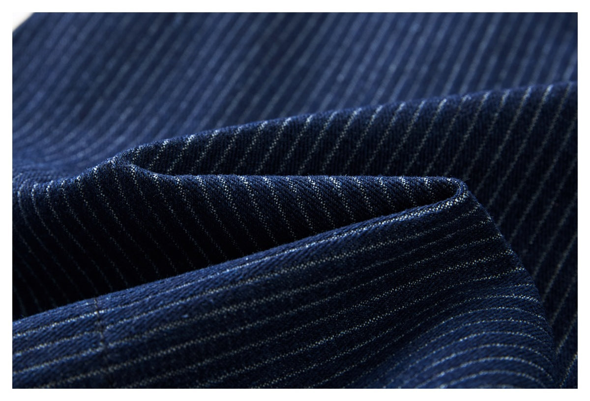 Close-up of dark navy pinstriped trouser fabric folded to show its texture and stitching.