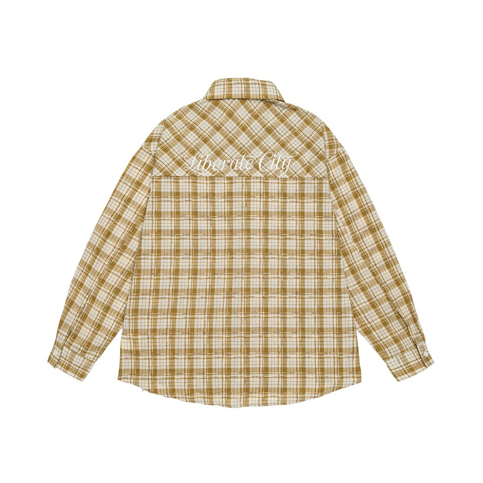 Back of a mustard-and-white plaid long-sleeve shirt with white script embroidery across the upper back.