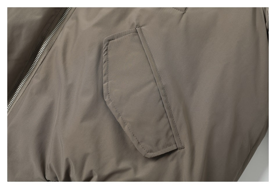 Close-up of a taupe jacket showing a slanted pocket and metal zipper.
