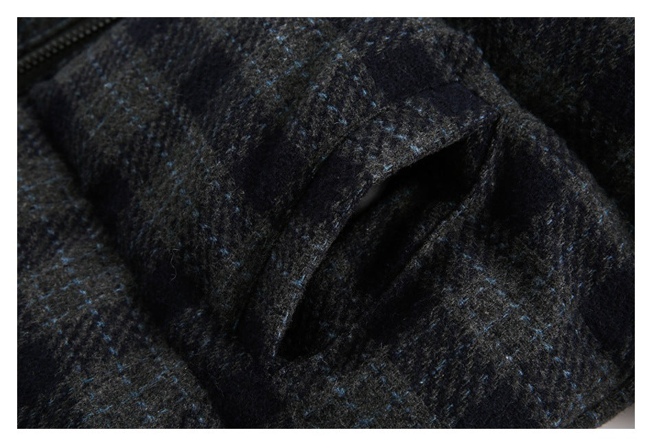 Close-up of a pocket opening and dark plaid fabric on the jacket.