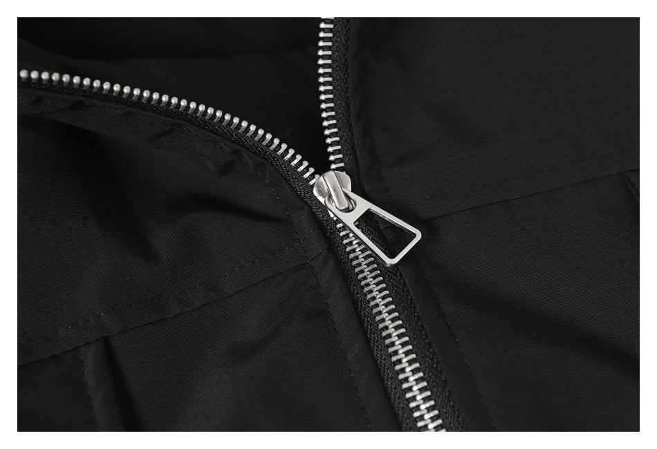 Close-up of a black jacket's silver front zipper and pull.
