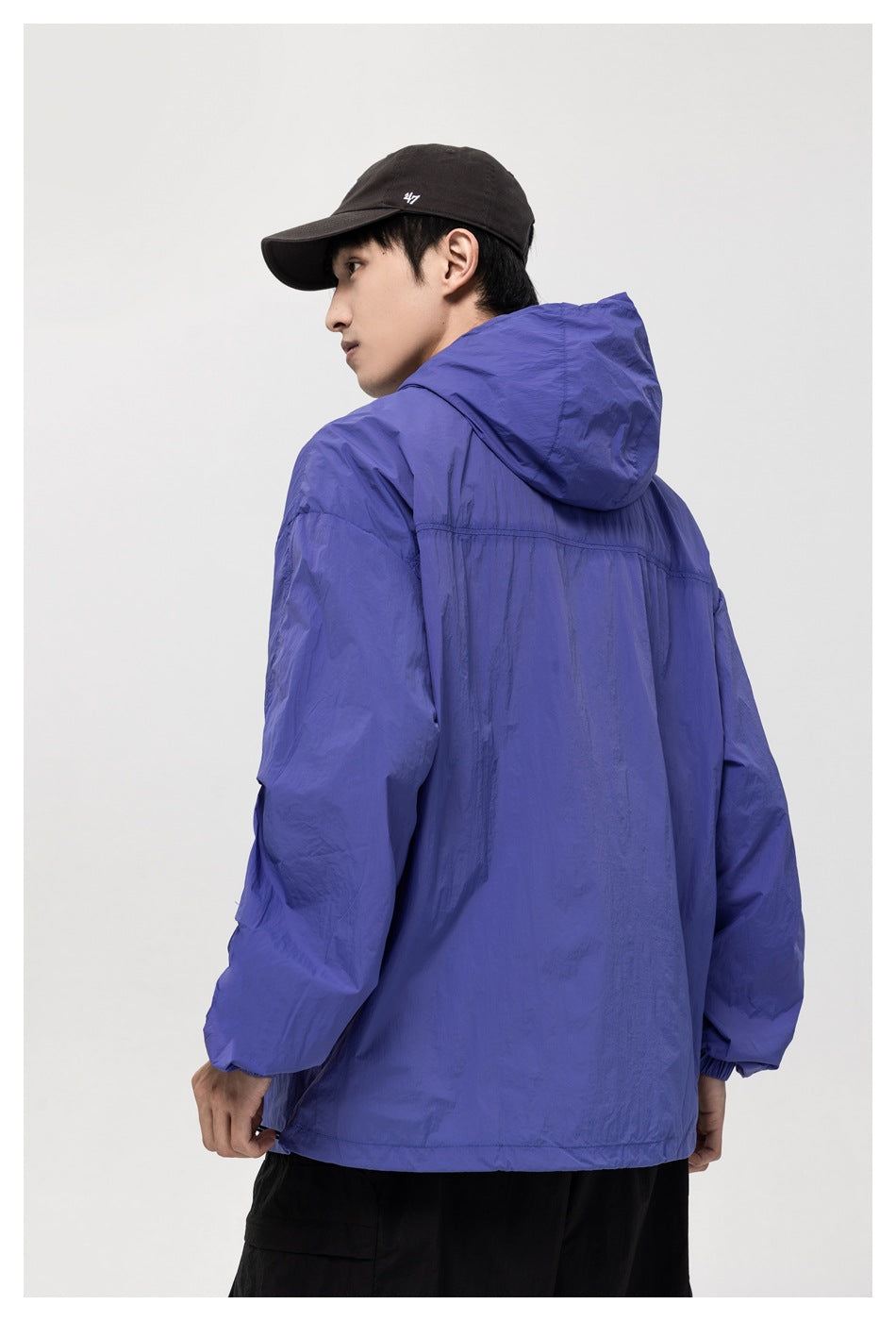 Model wearing a blue-purple hooded jacket, shown from the back and side.