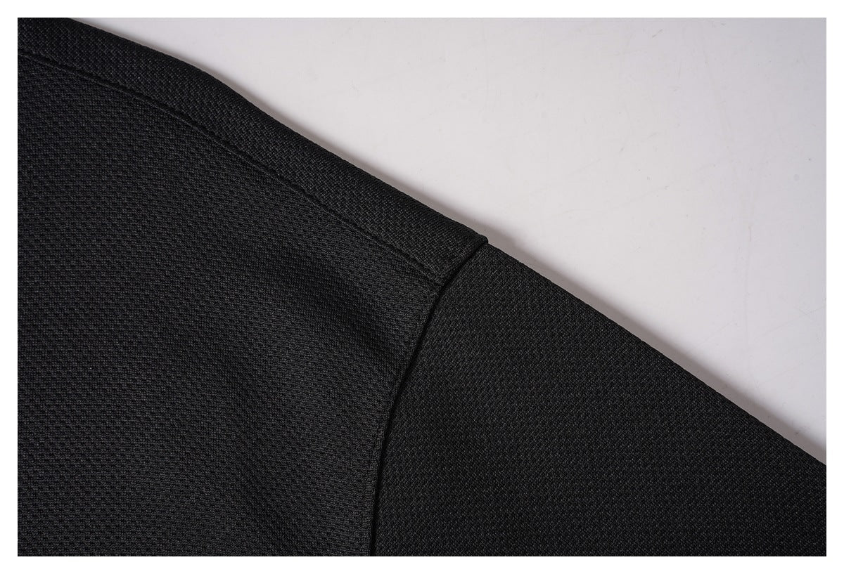 Close-up of the black shirt's shoulder seam and textured fabric.