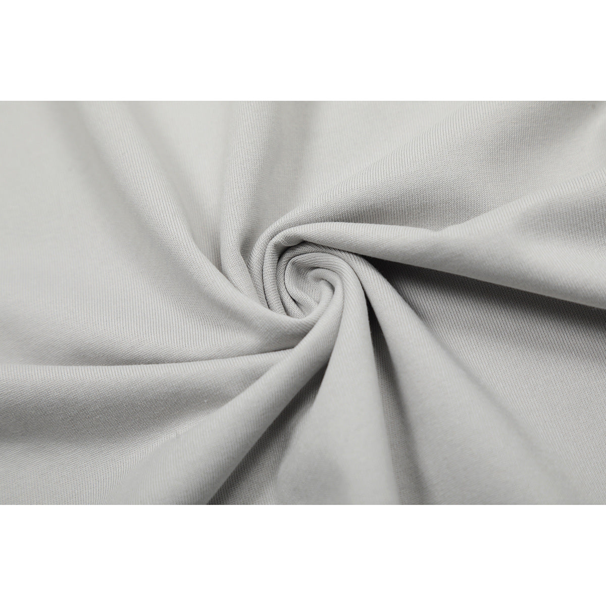 Close-up of light gray fabric gathered into folds, showing its surface texture.