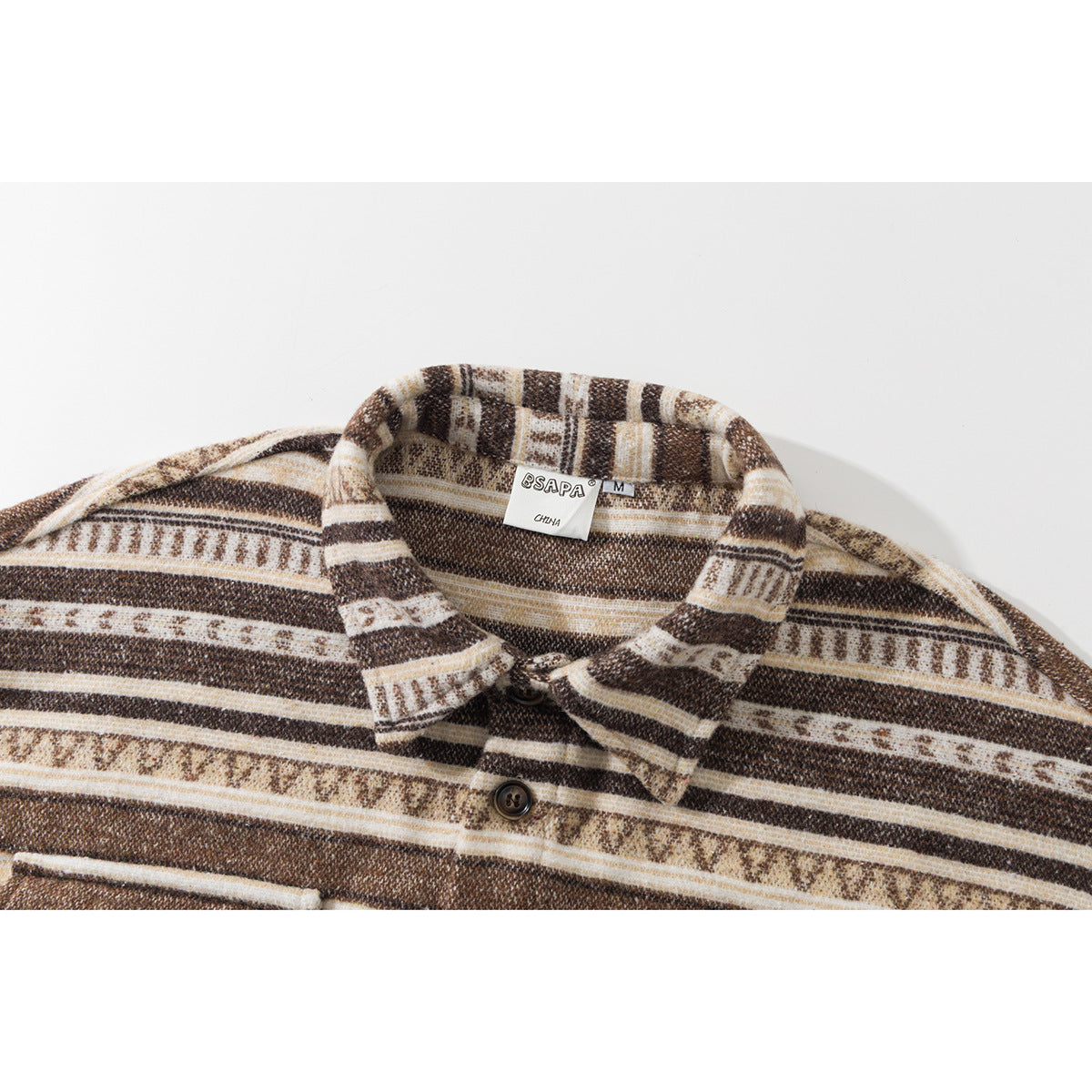 Close-up of a brown, cream, and tan patterned shirt collar, placket, and neck label.