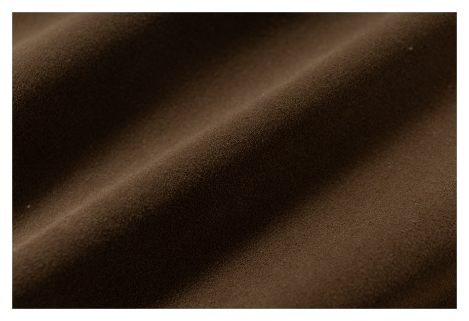 Extreme close-up of the brown garment's fabric surface and texture.