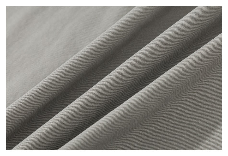 Close-up of gray fabric showing its fine diagonal weave and soft folds.