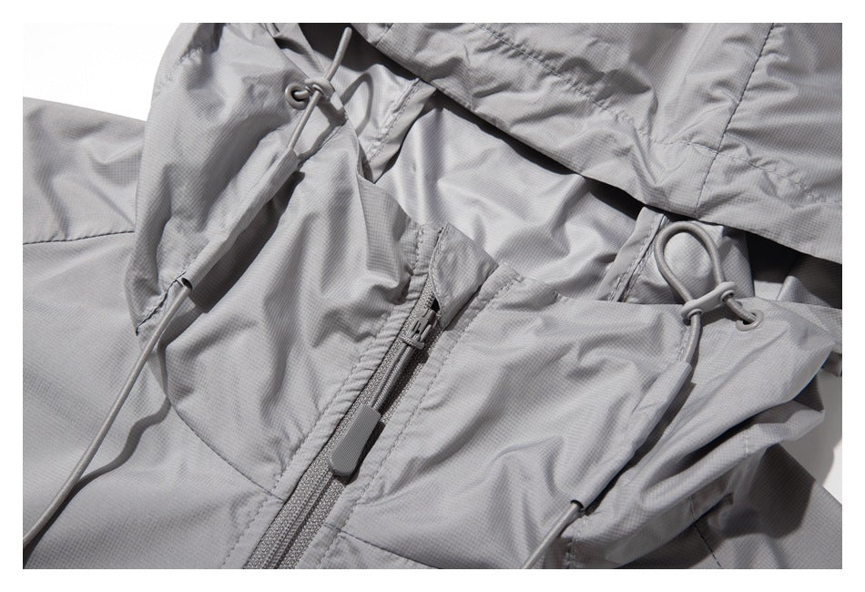 Close-up of the light gray jacket hood drawcord toggles and front zipper.