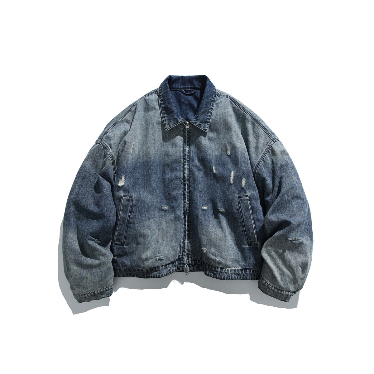 Washed blue distressed denim zip jacket with pointed collar and front pockets, laid flat