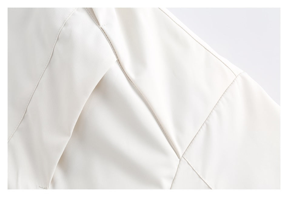Close-up of ivory jacket fabric panels and stitched seams.