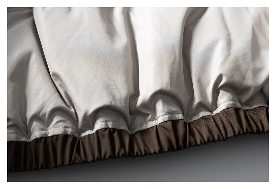 Close-up of a white jacket lining gathered into a brown elasticized hem.