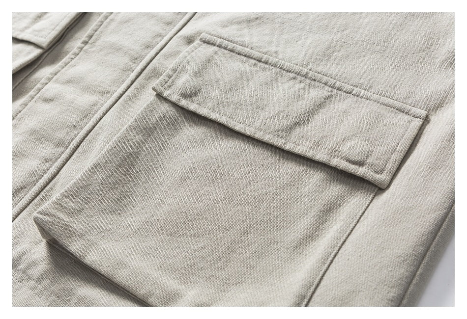 Close-up of a large rectangular flap pocket on the beige jacket.
