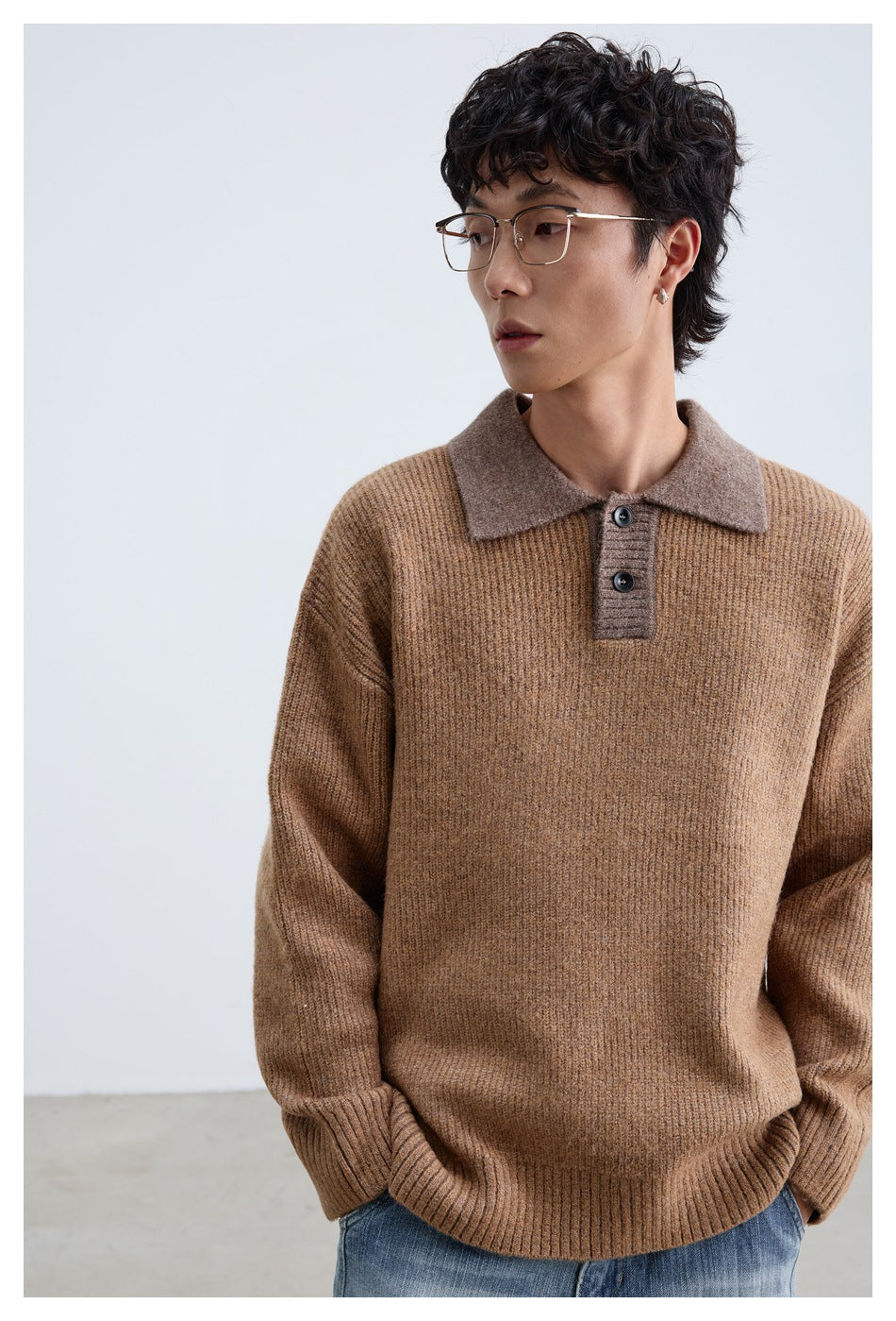 Close-up of a model wearing a brown ribbed polo-collar sweater with a taupe collar and two buttons, hands in pockets