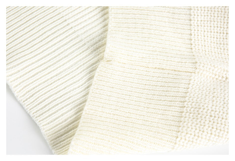 Close-up of a cream sweater cuff with a wide ribbed knit band.