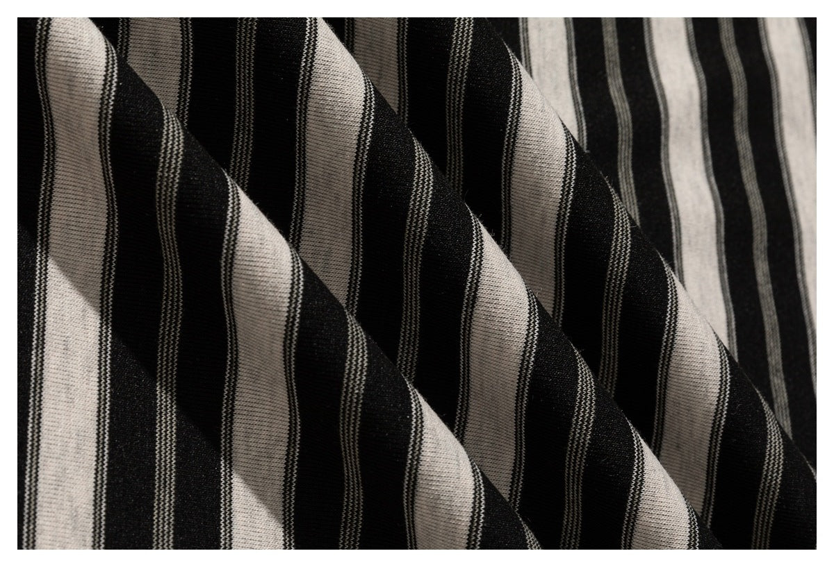 Macro view of black and cream striped fabric gathered into soft folds.