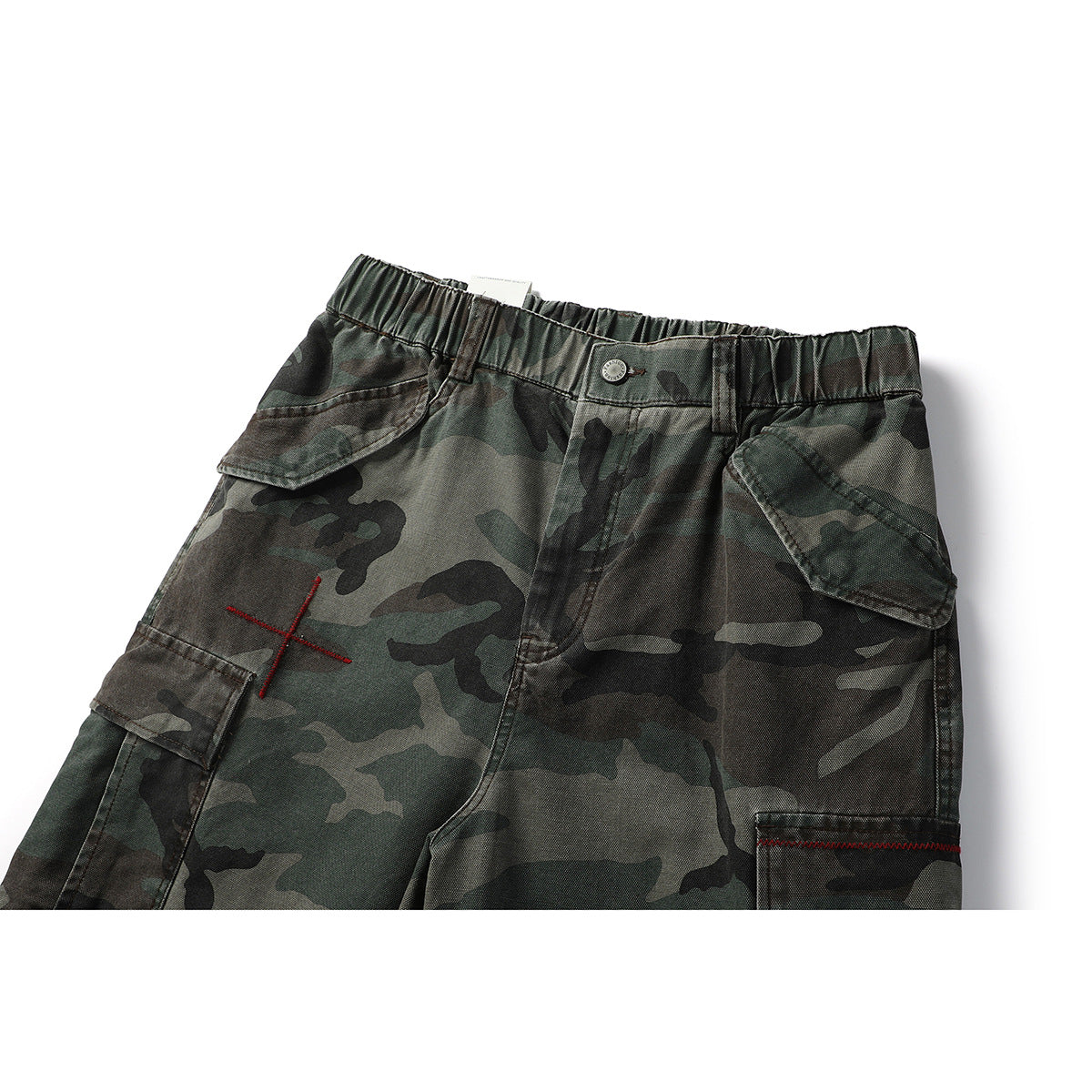 Cropped front view of dark green camouflage cargo shorts with an elastic waist, flap pockets and red stitching.