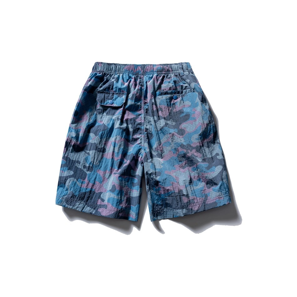 Back view of blue, navy, and pink camouflage shorts with an elastic waistband and two buttoned pockets.