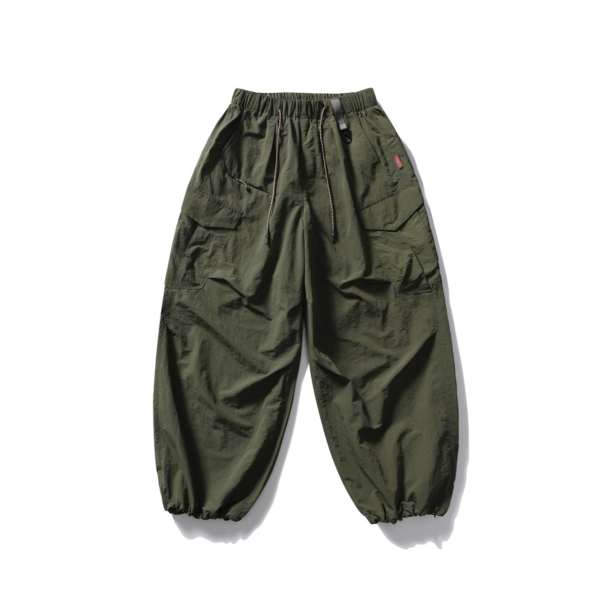 Olive green oversized cargo pants with an elastic drawstring waist, flap pockets and gathered ankle cuffs.