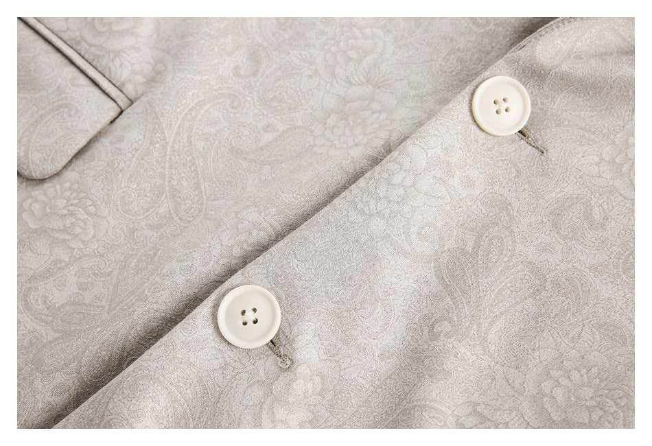 Close-up of two cream buttons on the pale beige floral-paisley blazer.
