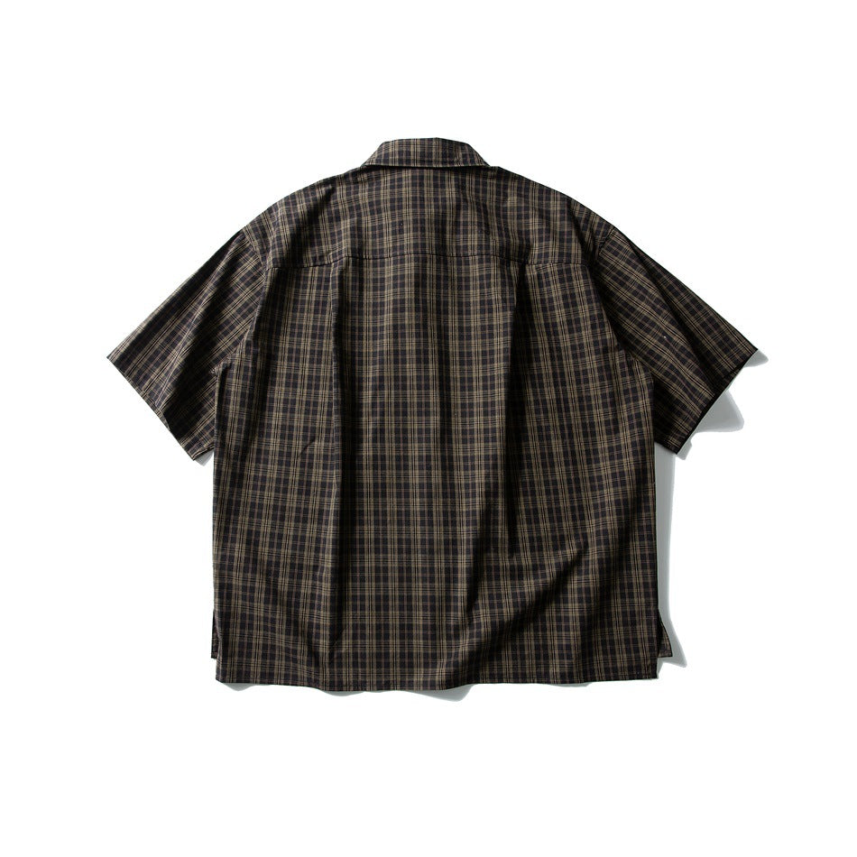 Back view of dark brown plaid short-sleeve shirt with back yoke seam and side slits, flat lay