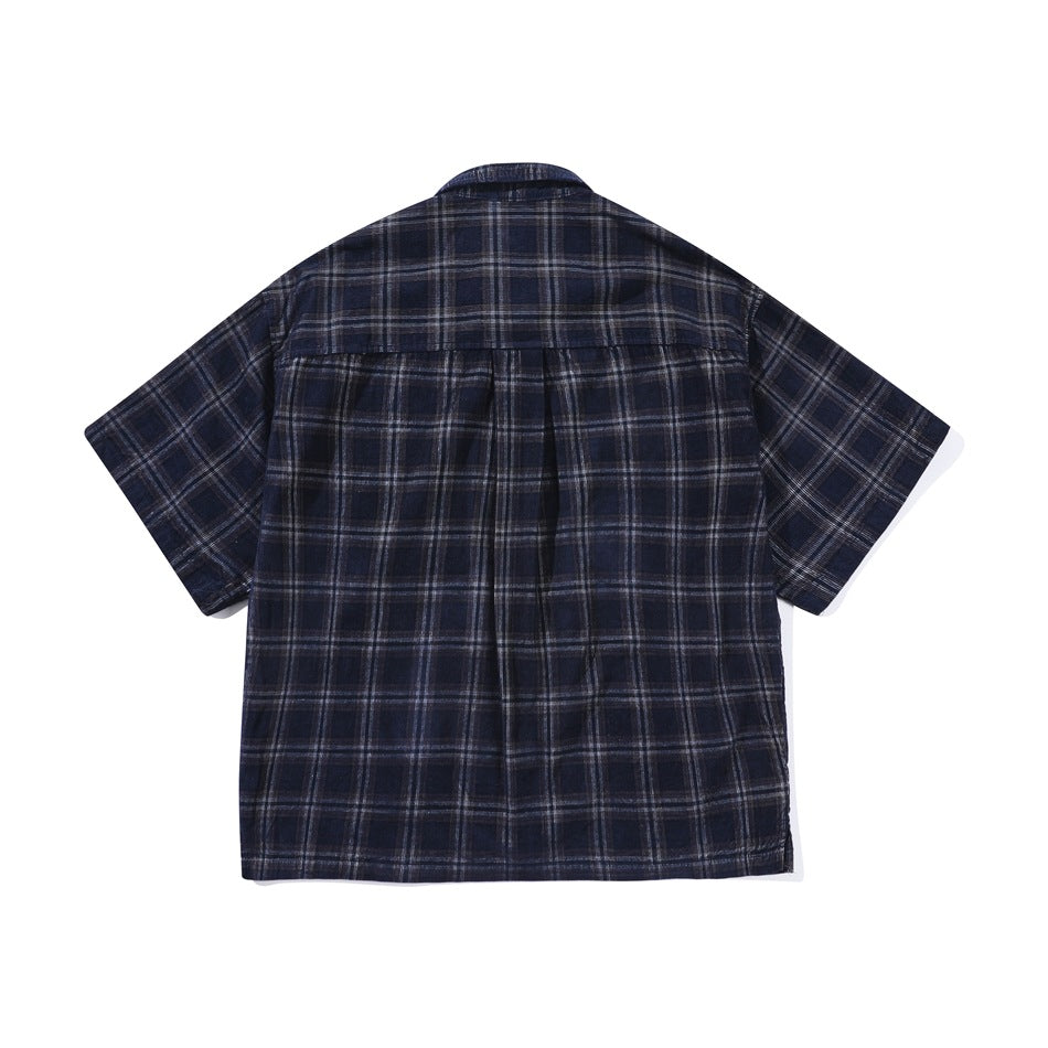 Back flat lay of a navy blue plaid short-sleeve shirt showing the back yoke and center pleat