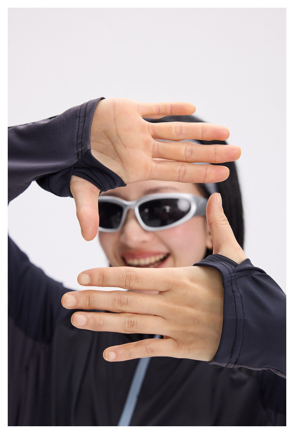 Close-up of a woman wearing a dark navy long-sleeve top with thumbhole cuffs.