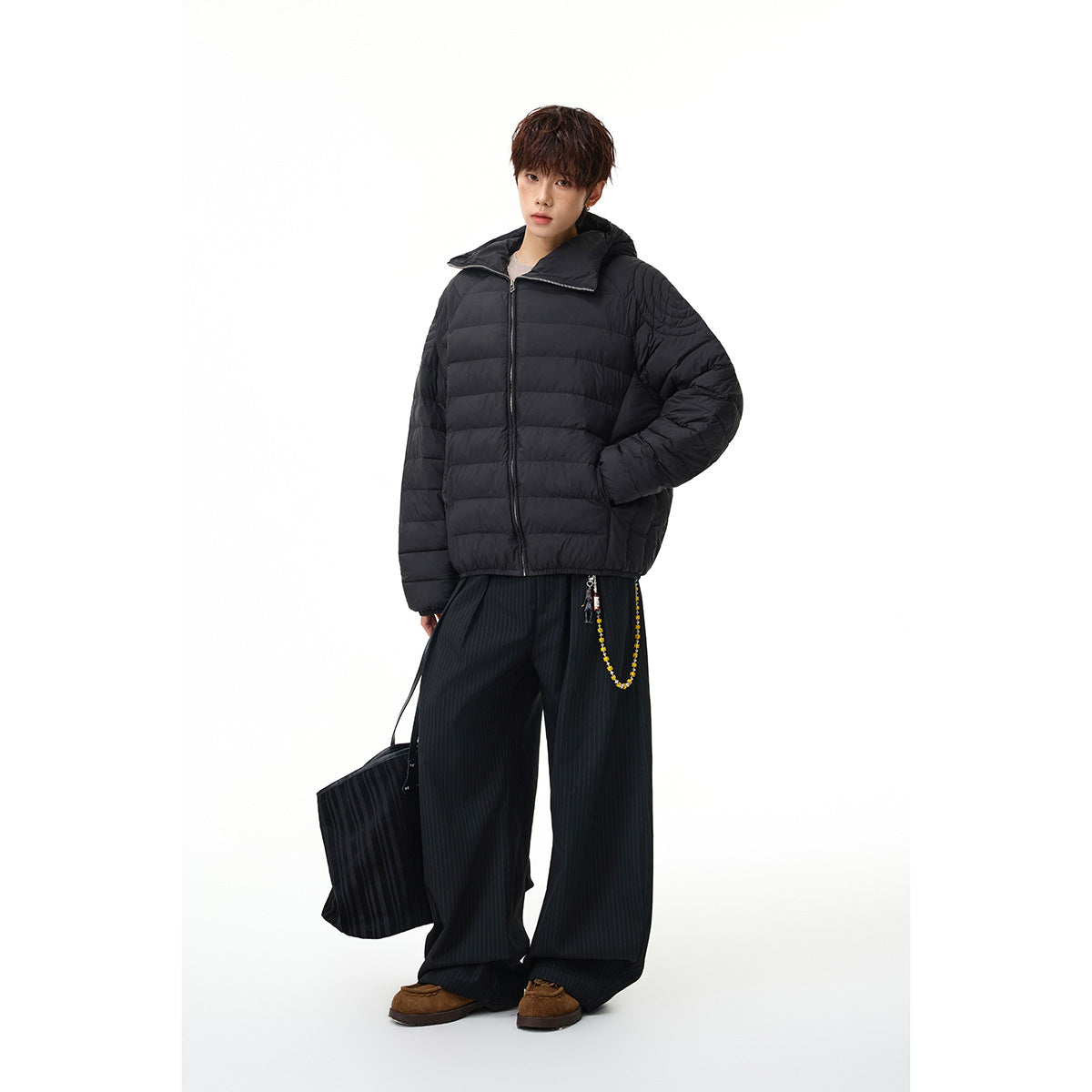 Model wearing a black quilted zip-front jacket with a wide collar and horizontal padded panels.