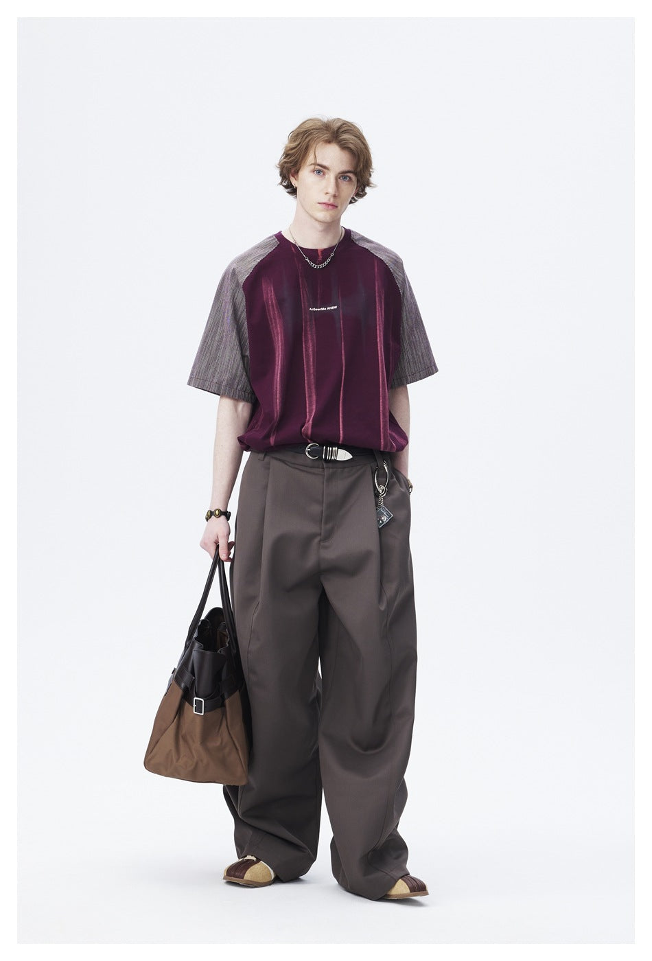 Front view of a model wearing a burgundy shirt with vertical accents and gray striped raglan sleeves.