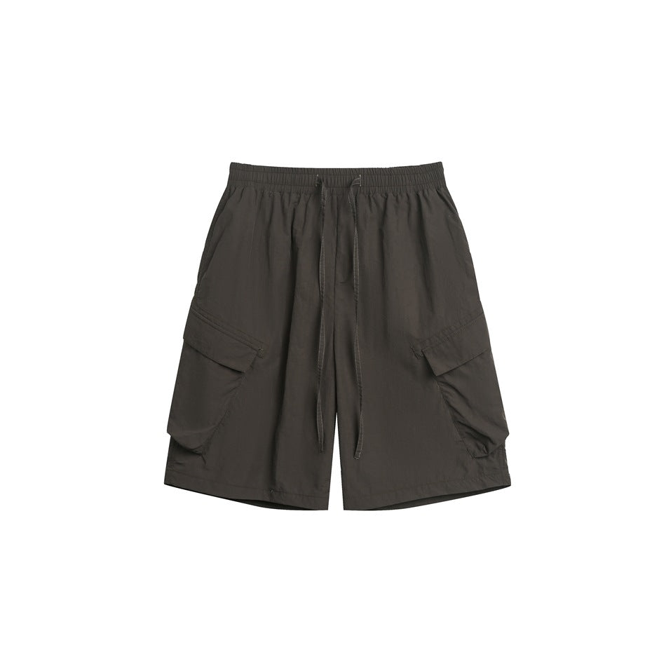 Dark gray-black cargo shorts with drawstring waist and large side flap pockets, flat lay front view