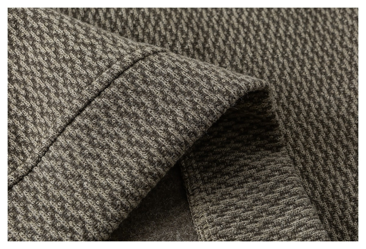 Close-up showing a seam and folded edge on gray-brown textured fabric.