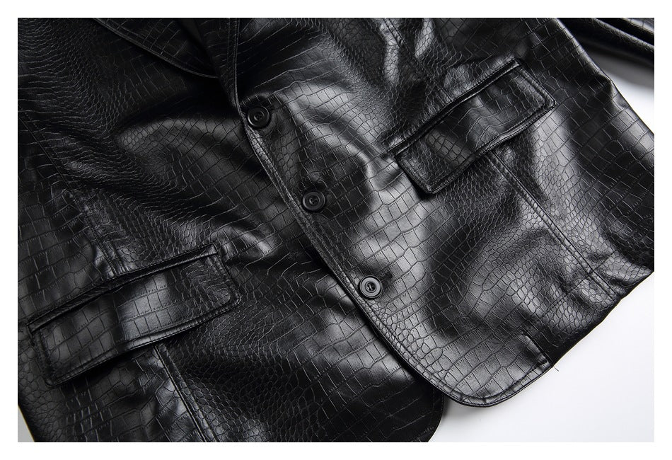 Close-up of the black jacket front showing three buttons, crocodile-textured panels, and flap pockets.