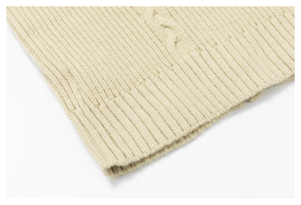 Close-up of the ribbed hem edge on a cream-colored knit garment.
