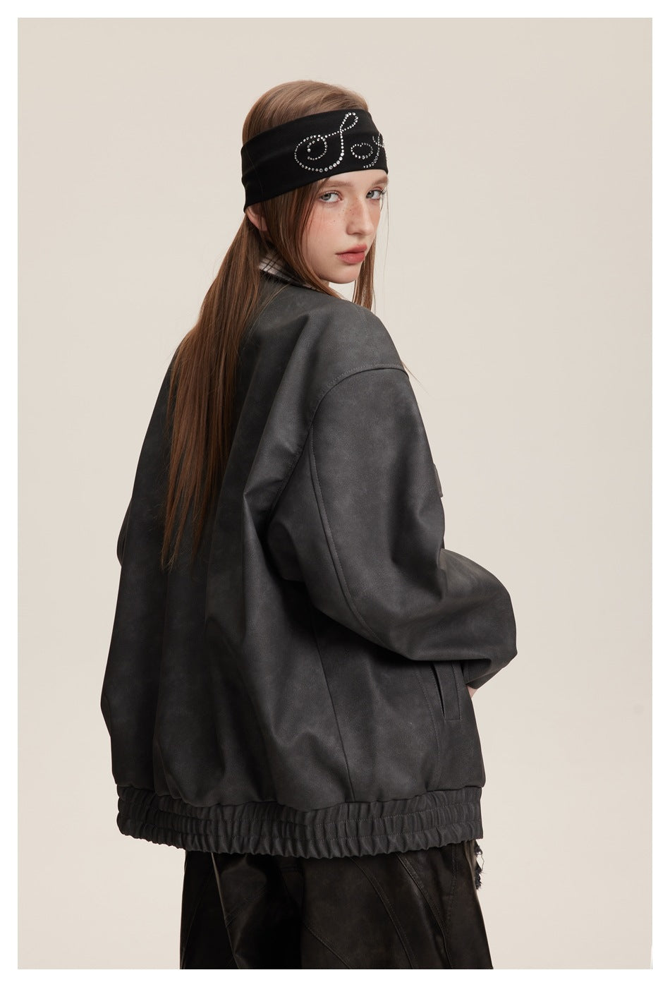 Model in an oversized charcoal jacket with a gathered hem, shown from the back and side.
