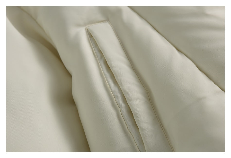Close-up of a narrow pocket opening and stitching on a pale cream garment.