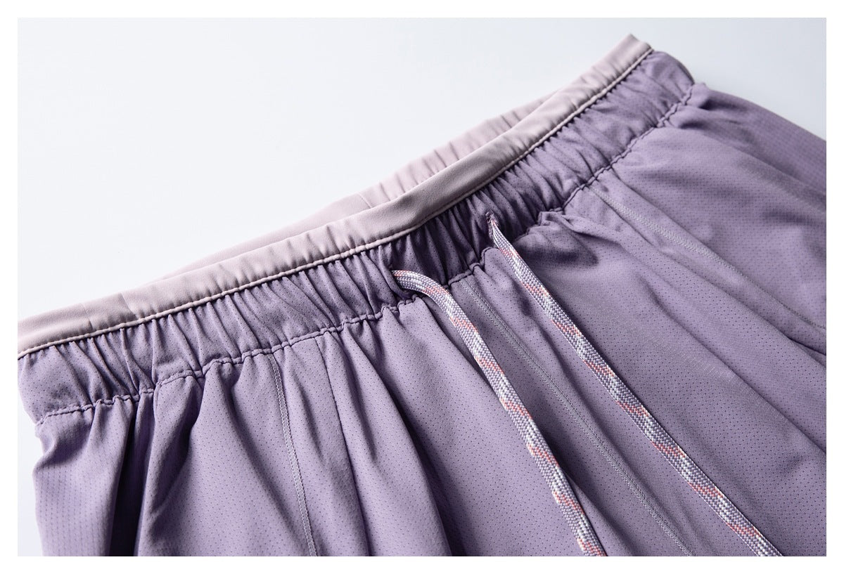 Close-up of lavender shorts showing the elastic waistband, pale trim, and patterned drawstrings.