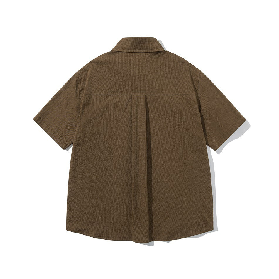 Brown short-sleeve shirt back view with yoke seam and center box pleat