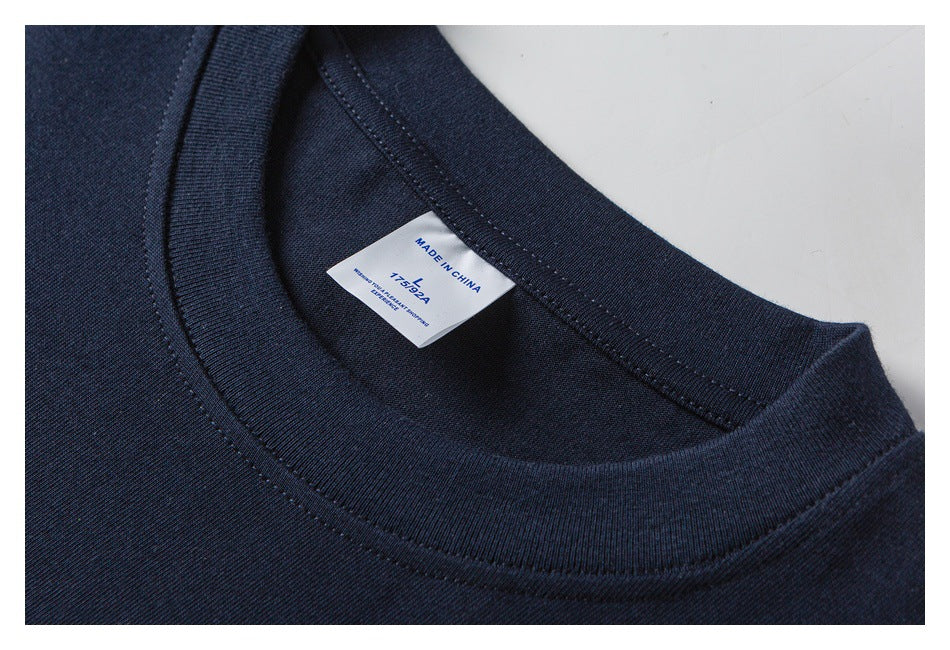 Close-up of a navy T-shirt's crew neckline and inner label, marked “Made in China.”