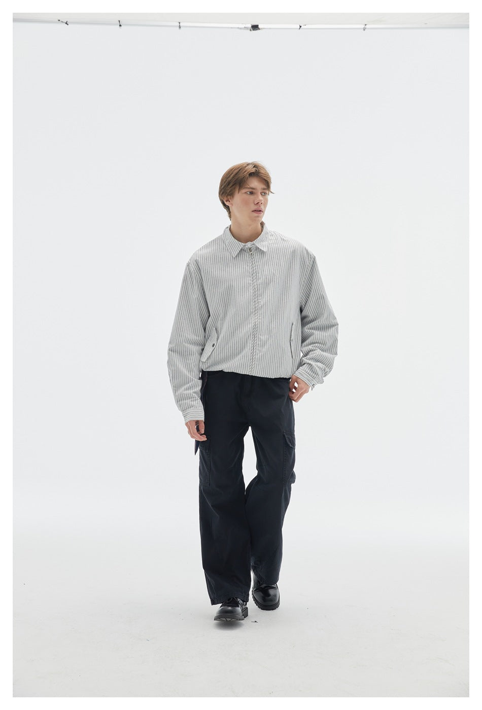 Model wearing a light gray pinstriped zip-front jacket with black cargo pants.