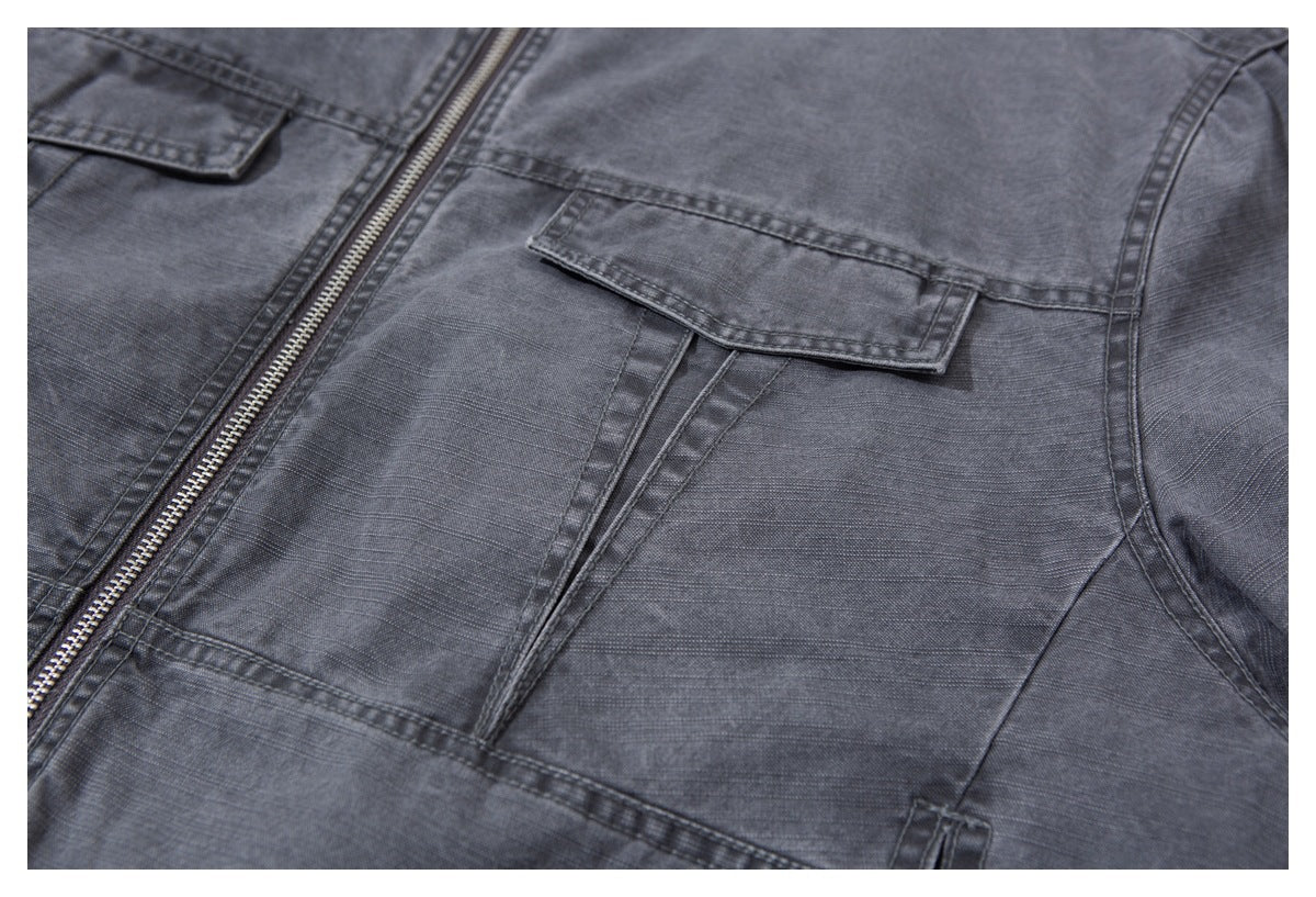 Close-up of the charcoal-gray jacket's front zipper and flap chest pockets.