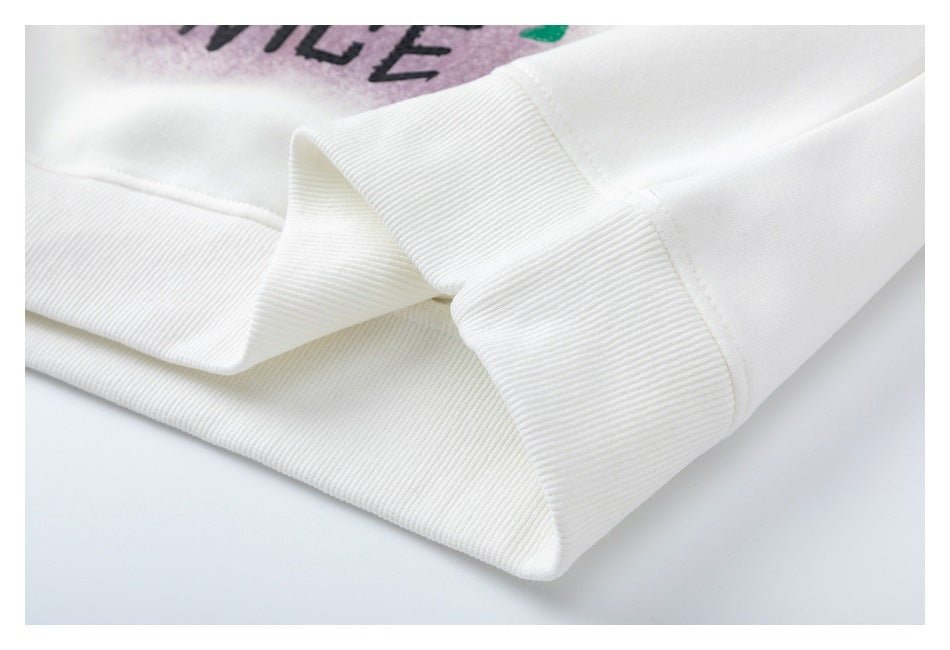 Close-up of the white sweatshirt's ribbed hem and seam, with part of its colorful print visible.