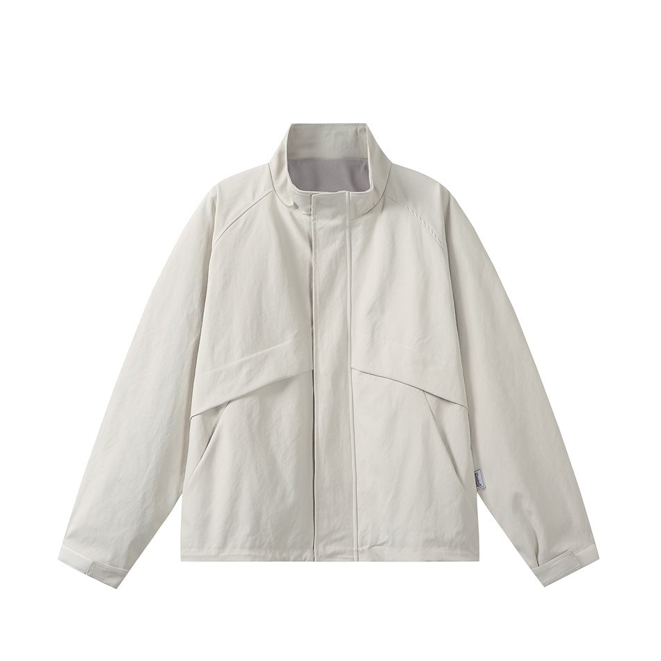 Beige stand-collar jacket, front flat lay, covered placket, raglan sleeves, angled seams and cuff tabs