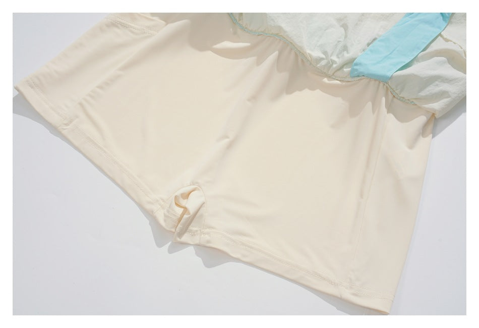 Inside view of the cream garment with smooth lining, hem stitching, and a pale blue fabric section.