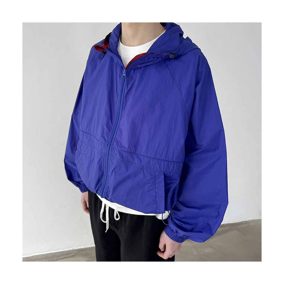 Person wearing a blue hooded zip jacket over a white tee and black pants, close-up of the cropped boxy fit