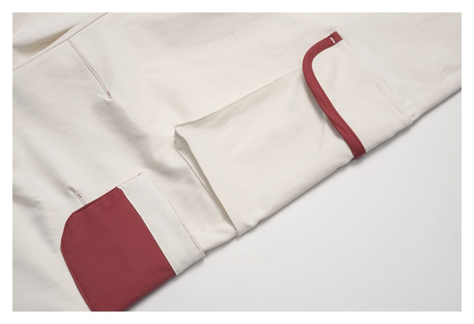 Close-up of an ivory cargo pocket with burgundy trim and contrasting pocket panel.
