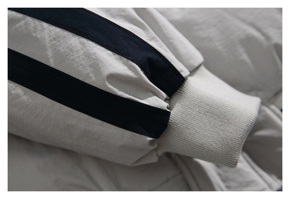 Close-up of the off-white jacket sleeve with two black stripes and a ribbed cuff.