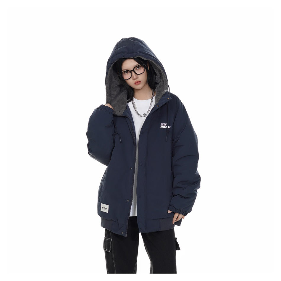 Model wearing a dark navy hooded jacket with gray lining, snap closure, and small chest and hem patches.